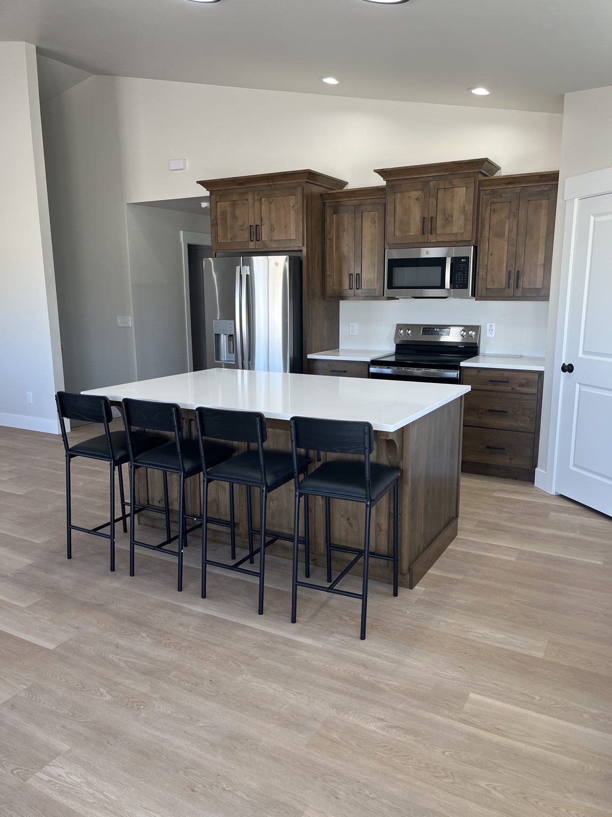 Open kitchen with walnut cabinets in the Summit home in Chubbuck, Idaho