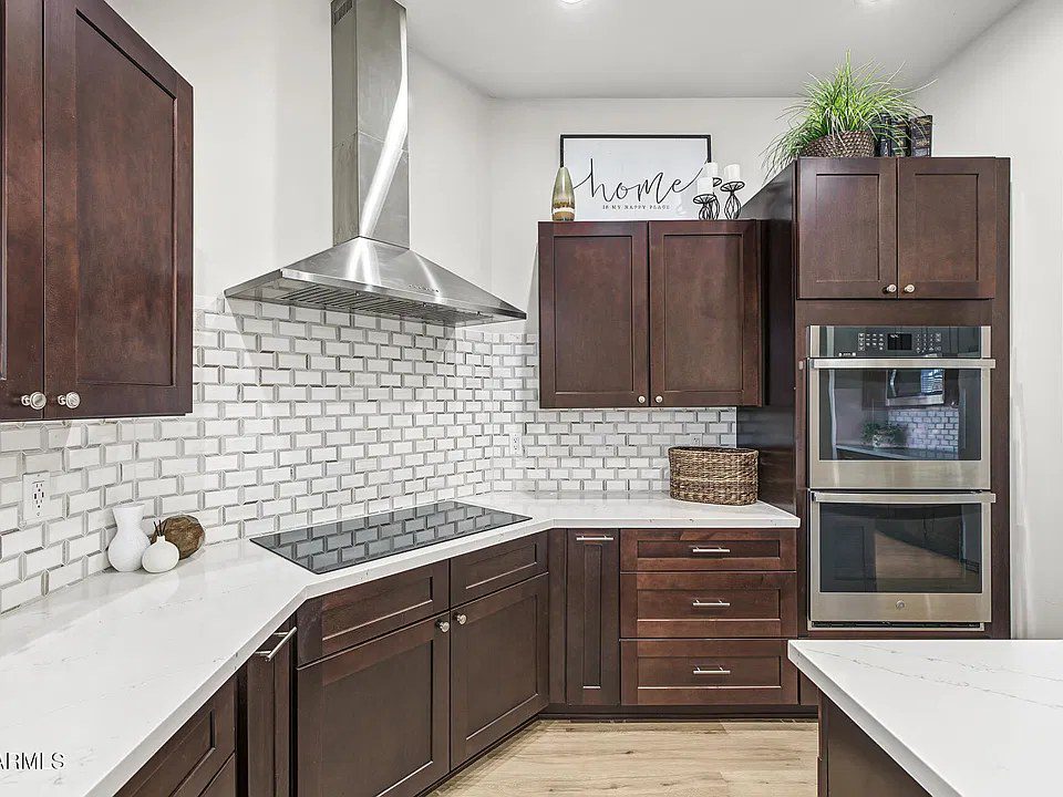 Kitchen with subway tile backsplash and double wall ovens in the Quartz estate